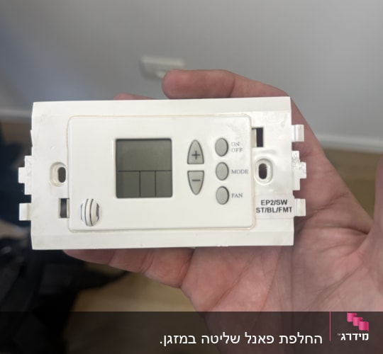 תרמוסטט של מערכת מיזוג אוויר מוחזק ביד